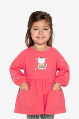 Child wearing the coral pink tunic with front patch pockets, front view