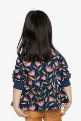 Child wearing the deep blue tulip print peplum top, back view