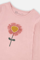 Close-up of the 3D embroidered pink flower with a mustard center on the tee