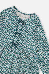 Close-up of the small bows and ditsy floral print on the green organic cotton dress