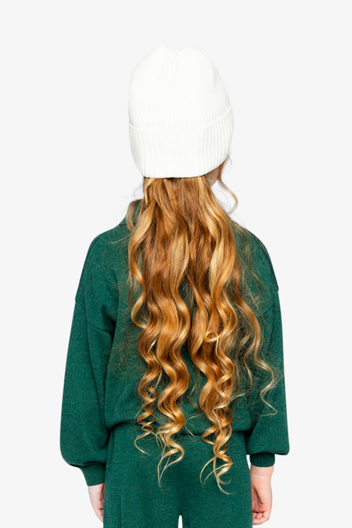 Child wearing the dark green knit sweater and white beanie, back view
