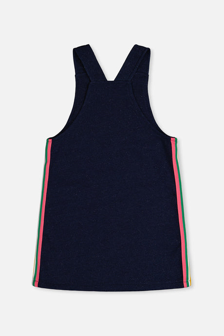 Deux par Deux girls navy overall dress with rainbow side stripes and crossed straps, back flat view