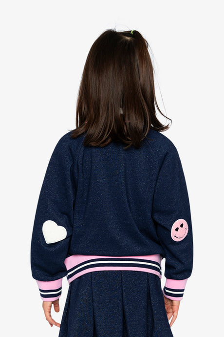 Child wearing the navy French terry bomber jacket, back view with a white heart and a pink smiley patch on the sleeves