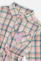 Close-up of the plaid collar, buttons and sequin heart pocket on the shirt dress
