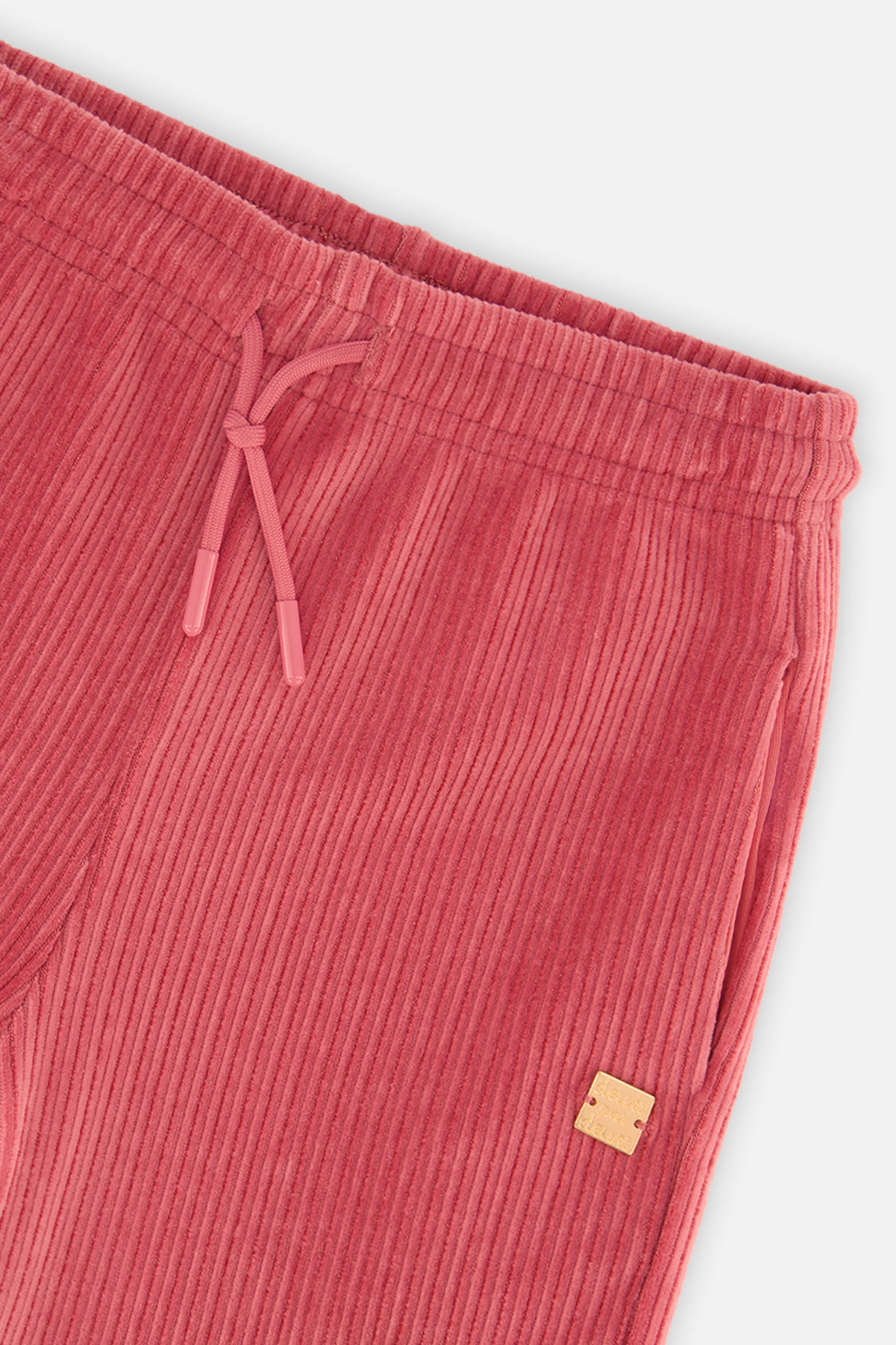 Close-up detail of the Deux par Deux raspberry pink velour flare pants