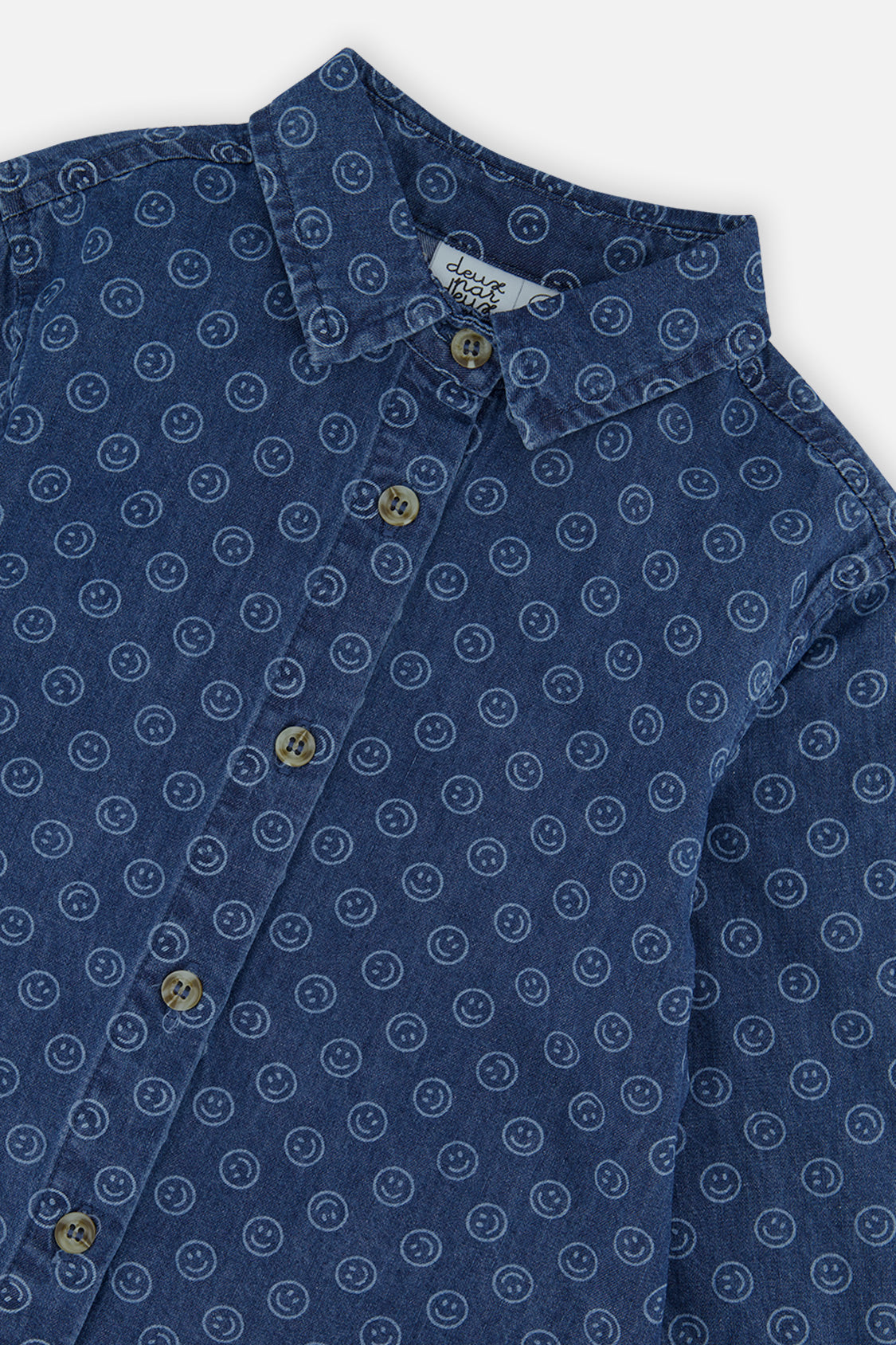 Close-up of the collar, buttons and small smiley faces on the blue chambray