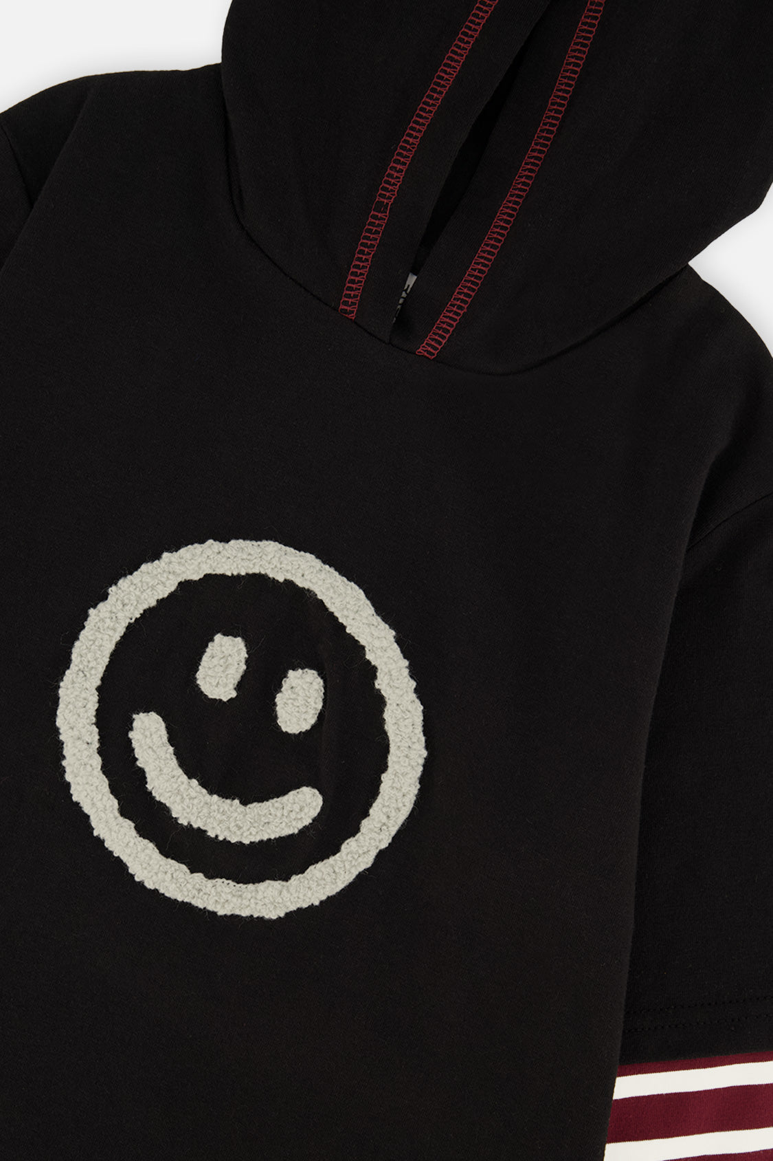 Close-up of the textured smiley face and contrast-stitched hood on the fake double sleeve hooded shirt