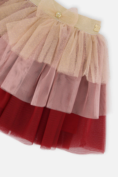 Close-up of the gold bow on the waistband and the glittering tiers