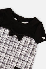 Close-up of the black bow and plaid knit on the front of the dress