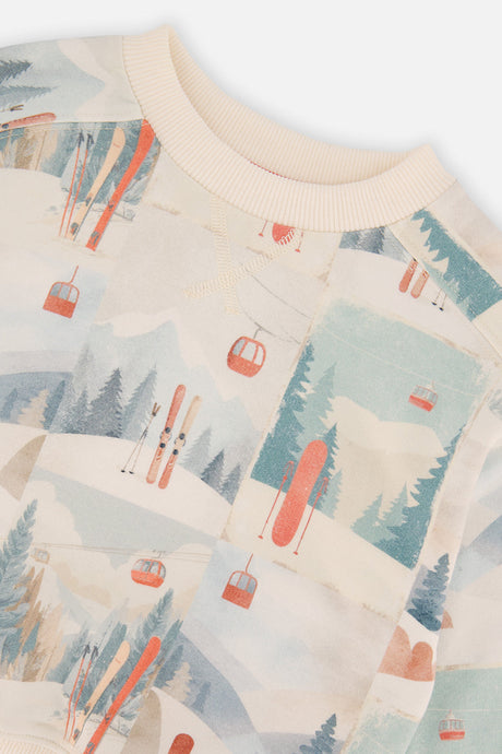 Close-up of the ribbed neckline and the gondolas skis and pine trees on the beige Deux par Deux sweatshirt