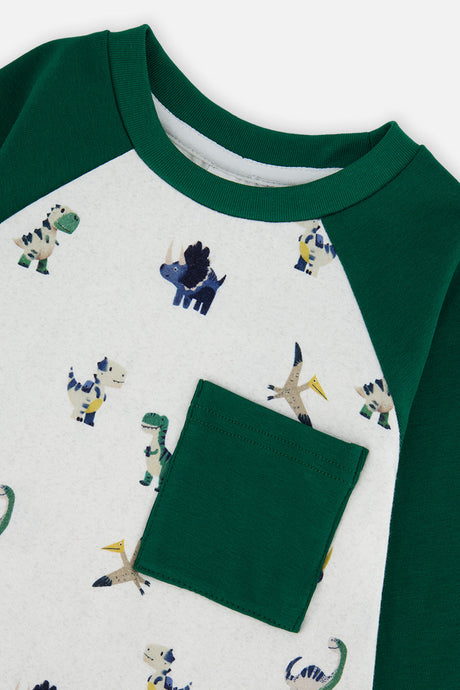 Close-up of the green chest pocket and the small dinosaur print on the beige tee