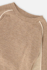 Close-up of the crew neckline and piped raglan seam on the taupe top
