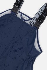 Water droplets on the dark blue polyurethane bib of the Deux par Deux rain overalls