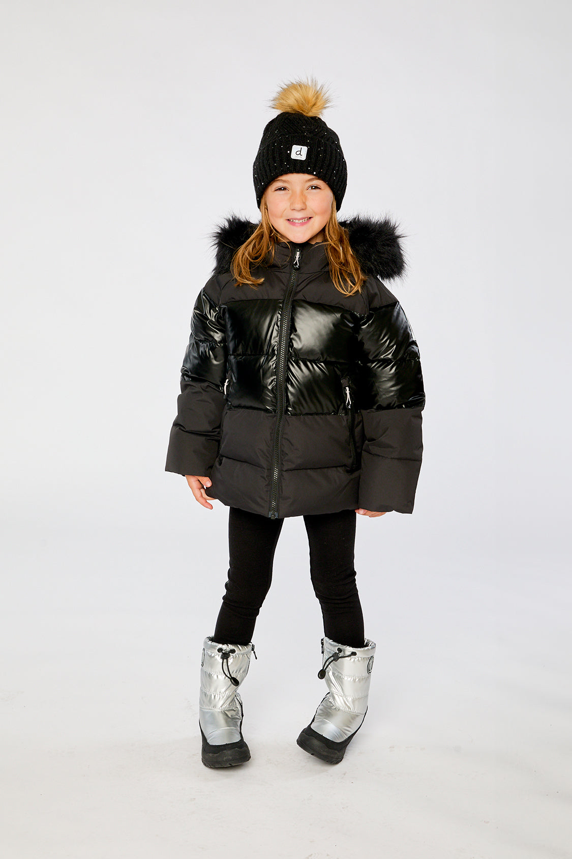 Child wearing the Deux par Deux black winter jacket with chest pattern, view 1