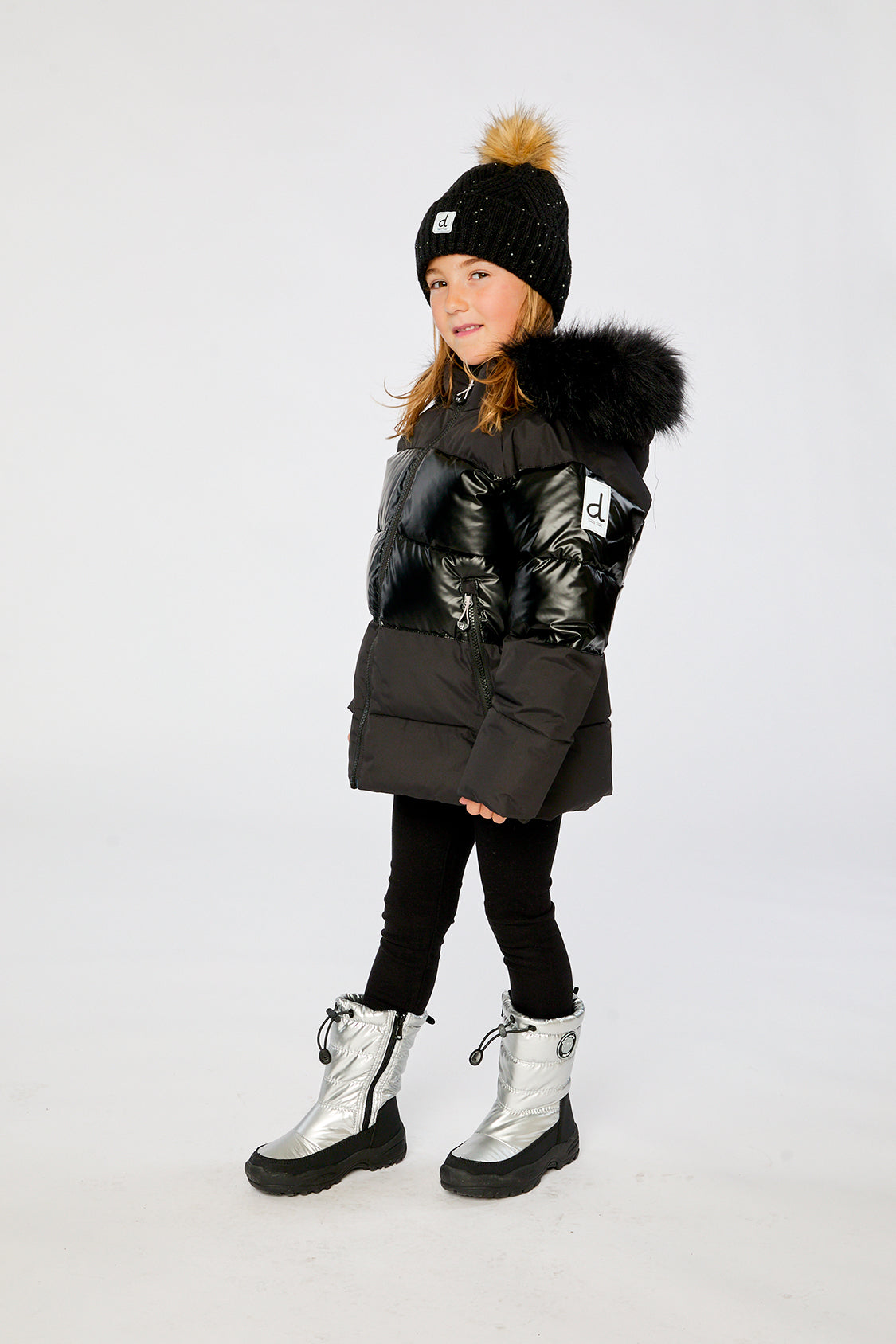 Child wearing the Deux par Deux black winter jacket with chest pattern, view 2