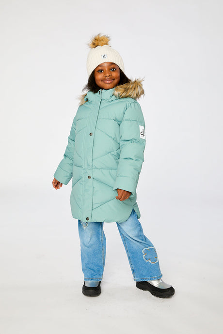 Child wearing the long sage green Deux par Deux puffer jacket with a faux-fur hood and cream pom-pom hat, front view