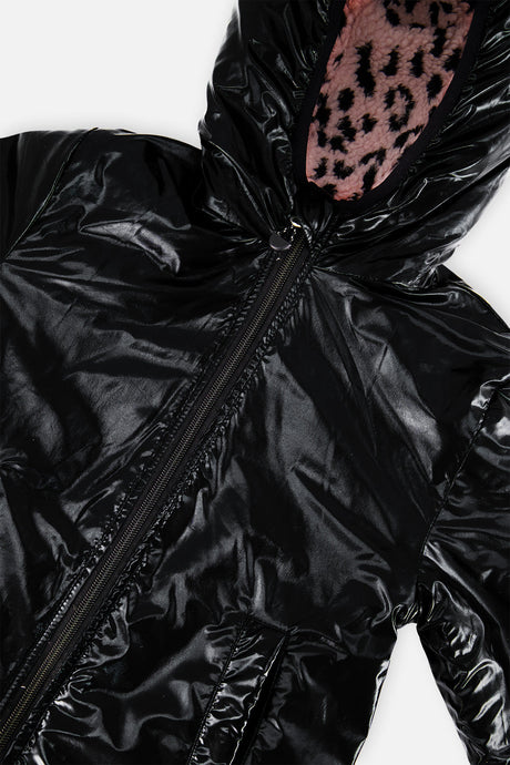Close-up of the glossy black side and the sherpa-lined hood opening of the reversible jacket