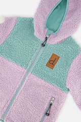 Close-up of the sherpa front, zipper and brown tag on the Deux par Deux reversible jacket