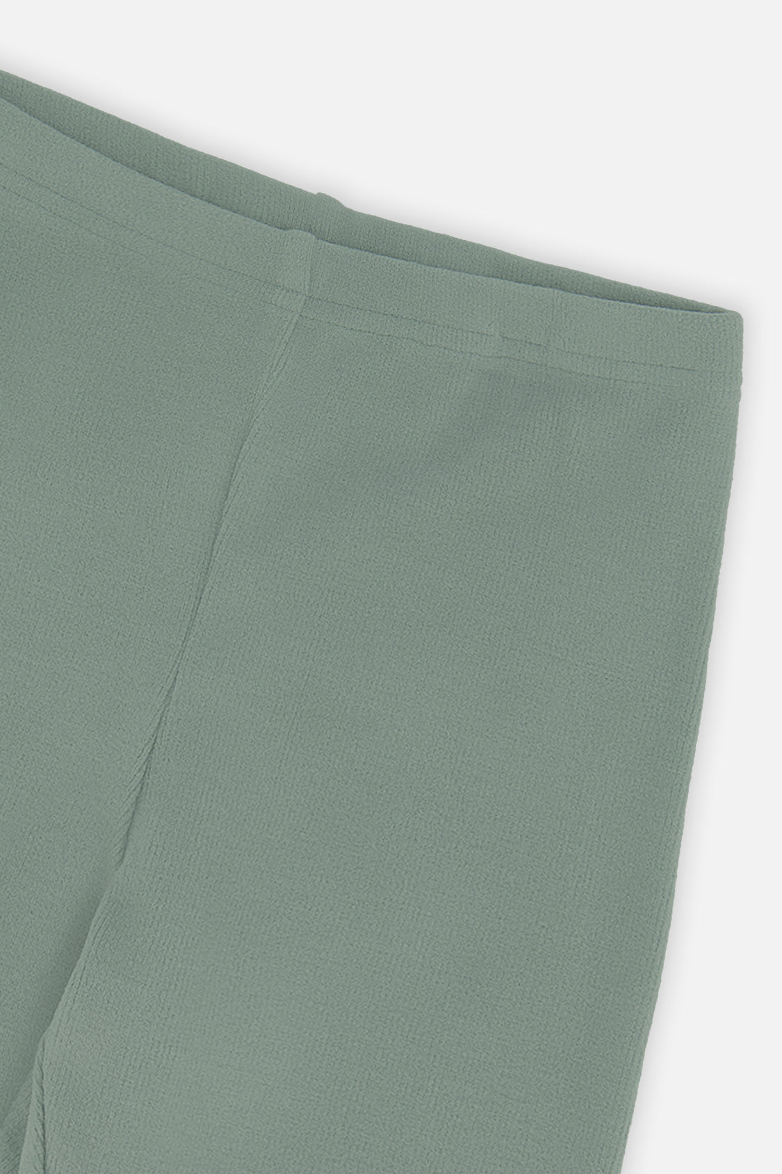 Close-up of the vertical rib texture and waistband on green leggings