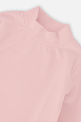 Close-up of the mock neck and rib knit on the pale dusty pink top