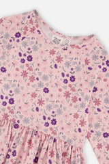 Close-up of the purple flowers, daisies and neckline label on the pink jersey