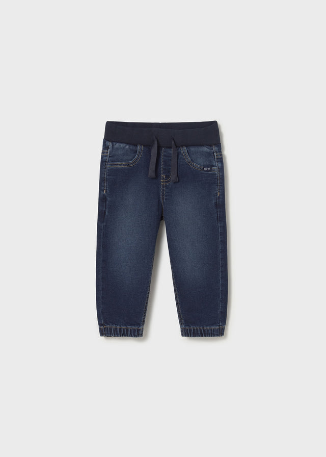 Front flat lay of dark denim jogger baby jeans showing tapered ankle.