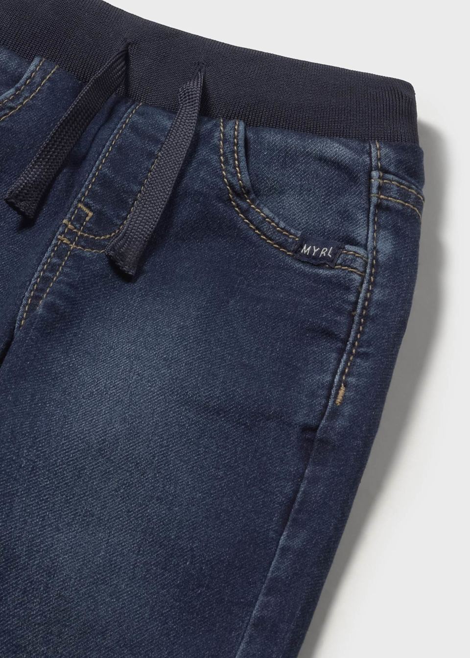 Closeup of waistband and drawstring on Mayoral kids denim pants.