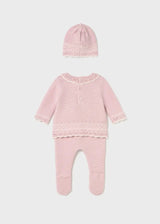 Full view of three-piece knit set for newborn girls with bow hat and footed pants.