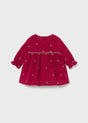 Front view of cherry-red polka-dot baby dress with long sleeves and gathered skirt.