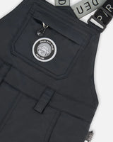 Closeup of Cordura® reinforced black bib overall with logo patch.