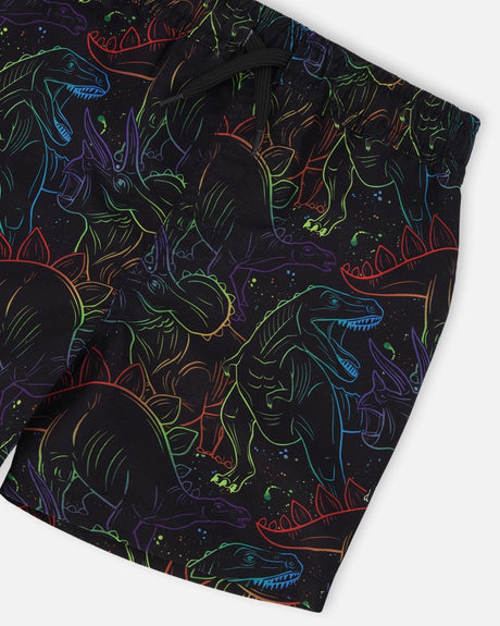 Close-up of waistband, drawstring, and neon dinosaur pattern on black swim shorts