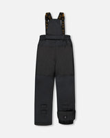 Black bib pants with Cordura knees and ankle gaiters, two-piece ski suit.