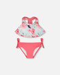 Flat lay of Deux par Deux girl blue flamingo print two-piece swimsuit with pink bottoms
