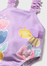 Closeup of Mayoral baby girl graphic swimsuit showing ruffled strap detail and colorful print.