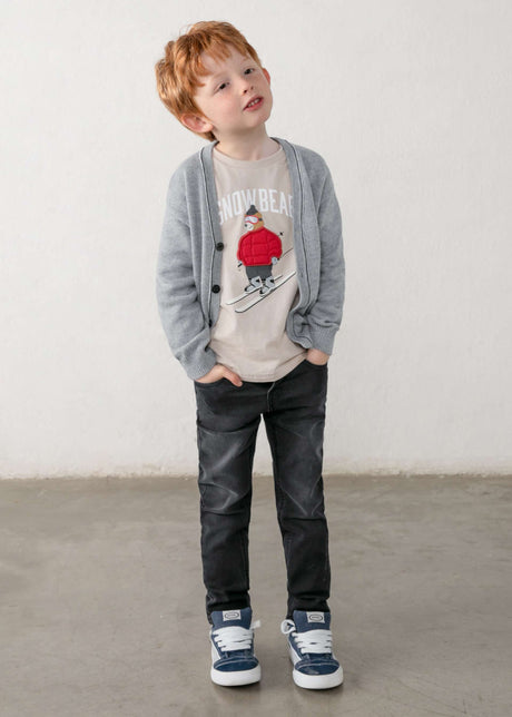 Child wearing black five-pocket Mayoral denim pants with a gray cardigan and high-top sneakers
